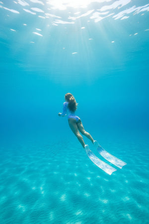 Freediver diving with Spierre Iridescent Scale ocean swim suit, matching Iridescent Scale carbon art fin blades